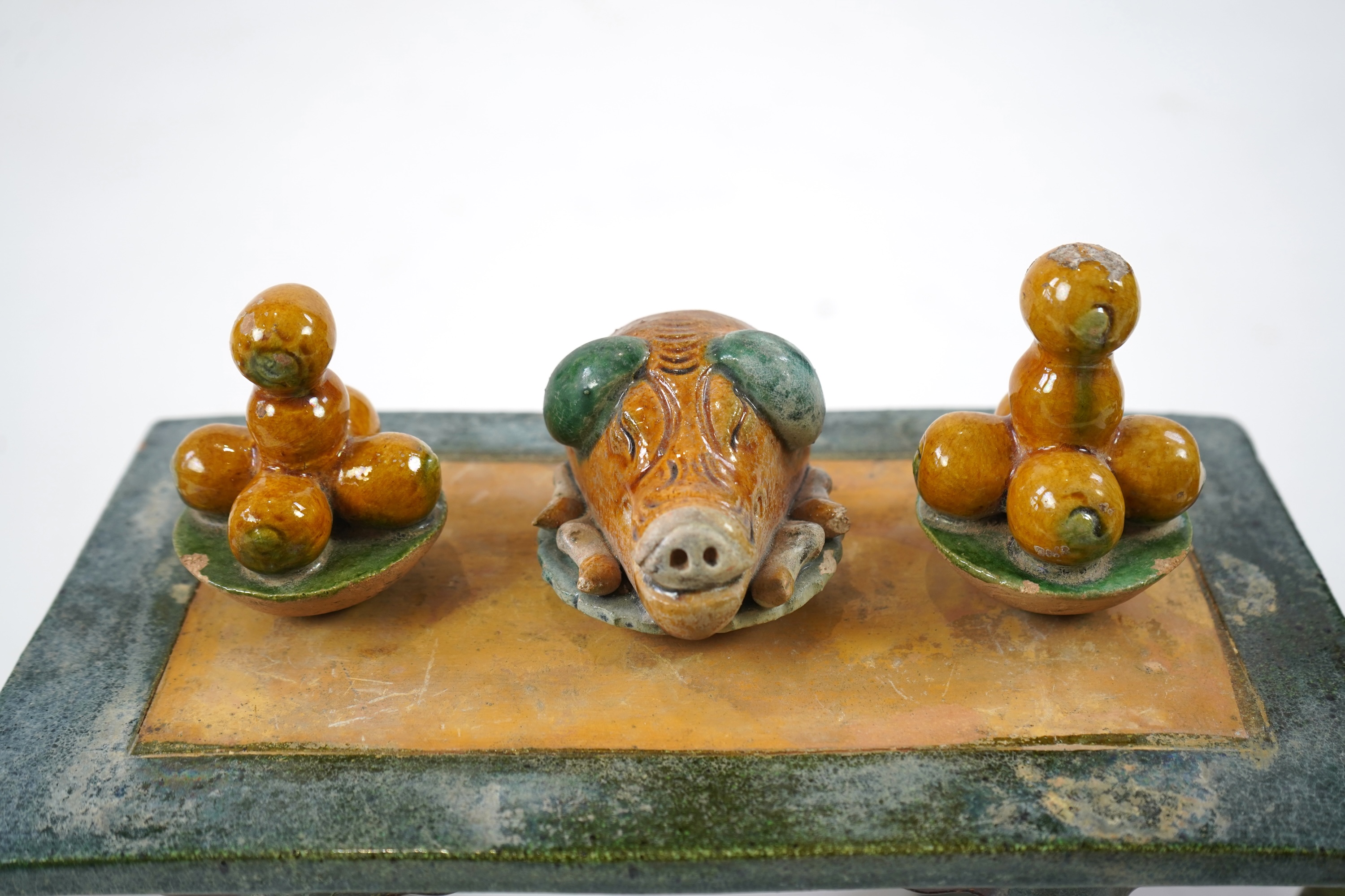 A set of Chinese Ming Sancai models of table with offerings and a pair of horseshoe shaped armchairs, 16th century
